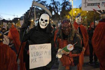 Manifestantes contrarios a las vacunas en Barcelona auguran la muerte a los vacunados rodeados de espartanos con cartelería sobre óxido de grafeno.