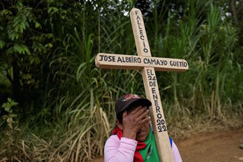 Una mujer porta una cruz con el nombre del líder indígena José Albeiro Camayo, recientemente muerto también en un ataque armado. 