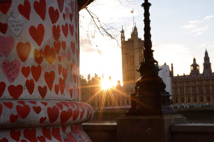 Los rayos del sol bañan el National Covid Memorial Wall, erigido cerca del Palacio de Westminster, en Londres.