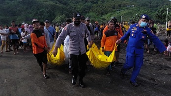 Los equipos de rescate trasladan los cuerpos de los fallecidos en la playa de Payangan, en Indonesia.