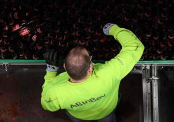 Un técnico comprueba botellas utilizadas en una línea de producción de la cervecería Stella Artois.