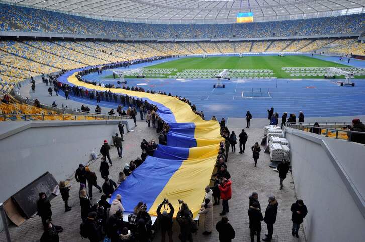 Cientos de personas desplegaron una bandera ucraniana en Kiev. 