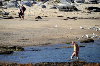 Paseantes y bañistas, cerca del lugar en el que tuvo lugar el ataque mortal, en Little Bay Beach.