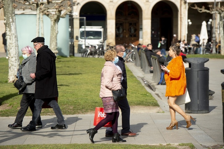 Personas paseando con y sin mascarilla por la plaza del Castillo de Iruñea.