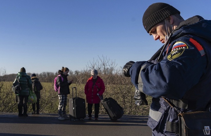 Civiles de Donbass esperan su evacuación junto a un miliciano rebelde pro-ruso.