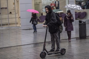 Un hombre conduce un patinete eléctrico en Iruñea. 