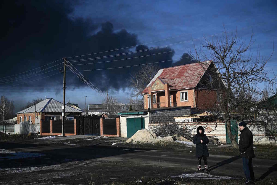 Una mujer que vive junto al aeropuerto militar de Chuguyev, cerca de Jarkiv. Al fondo, la columna de humo provocada por el ataque ruso. 