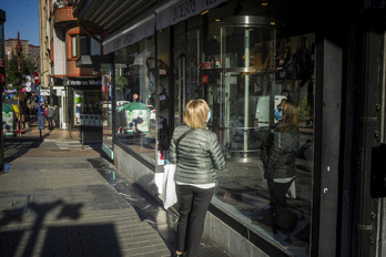 Una mujer mirando el escaparate de una tienda.