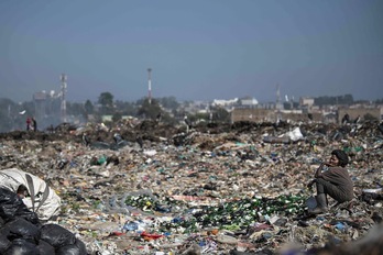 Un ‘reciclador’ descansa junto a una pila de botellas en el basurero de Dandora, donde la gente se gana la vida rebuscando materiales reutilizables y reciclables que se pueden vender en Nairobi, la capital de Kenia.