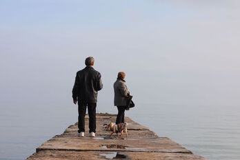 Una pareja pasea al perro en un espigón en el mar de Azov, en Mariupol.