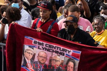 Un grupo de personas sostiene una pancarta de apoyo a Ahmaud Arbery en el 57º aniversario del «Domingo Sangriento» en Selma, Alabama, cuando la Policía atacó a manifestantes por los derechos civiles.