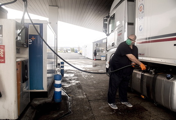 Un camionero recarga combustible en una gasolinera. 