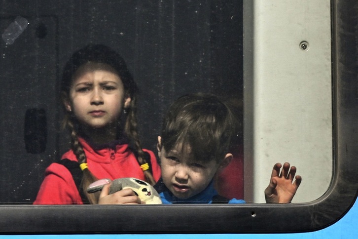 Dos niños ucranianos cruzan en tren la frontera entre Ucrania y Polonia.