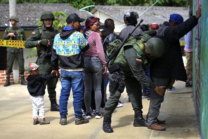 Un oficial de Policía cachea a un ciudadano en un colegio electoral de Toribio, en el departamento de Cauca.