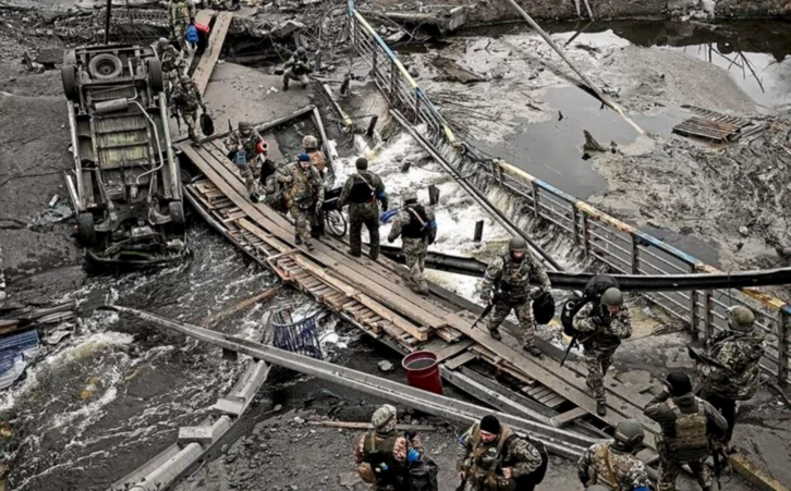 Militares ucranianos cruzan un río por un paso provisional cerca de Irpin.