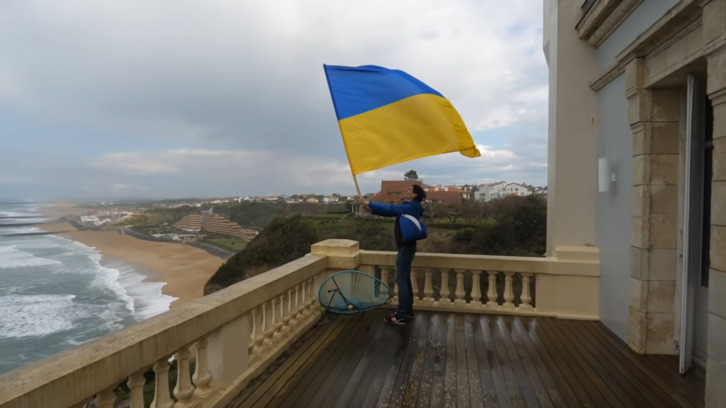 Uno de los activistas ondea la bandera ucraniana en el interior de la villa vinculada a Putin.