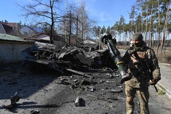 Soldadu bat tankeak suntsitzeko arma bat eusten ari da. 