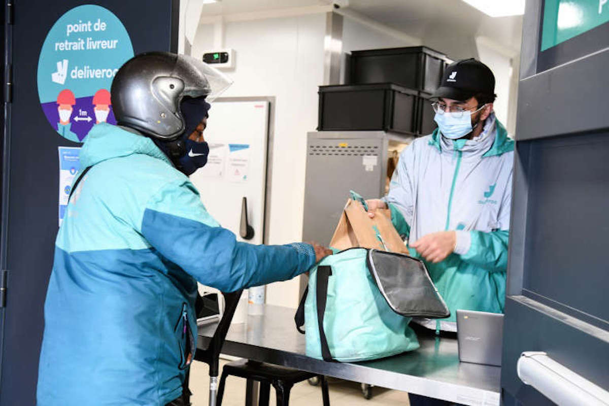 Un repartidor de Deliveroo recoge unos pedidos en la cocina de la compa&ntilde;&iacute;a en Aubervilliers, a las afueras de Par&iacute;s. (Alain JOCARD/AFP)