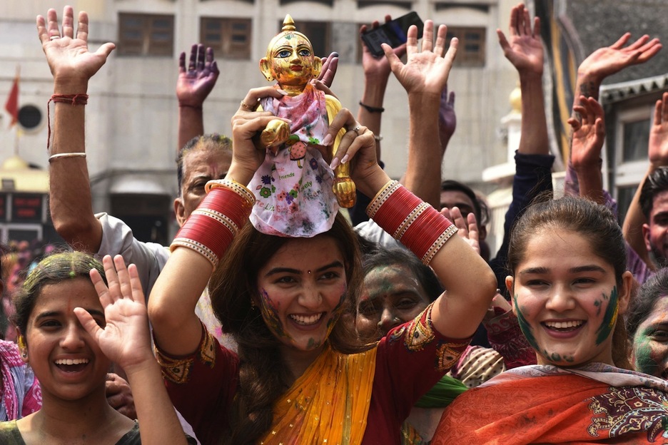 Una mujer porta una imagen de Krishna mientras se dirige al templo Durgiana de Amritsar.