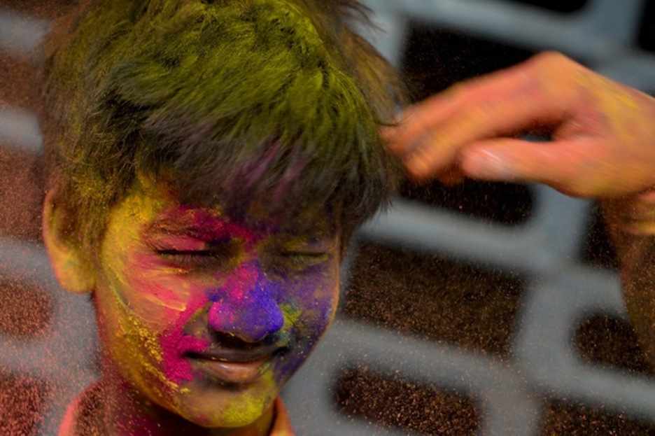 Un chaval hace un gesto con la cara pintada con ‘gulal’ mientras celebra el festival de primavera en Chennai.