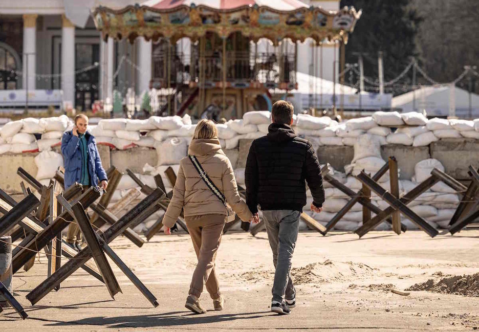 Una pareja camina cerca de un puesto de control en Kiev. 