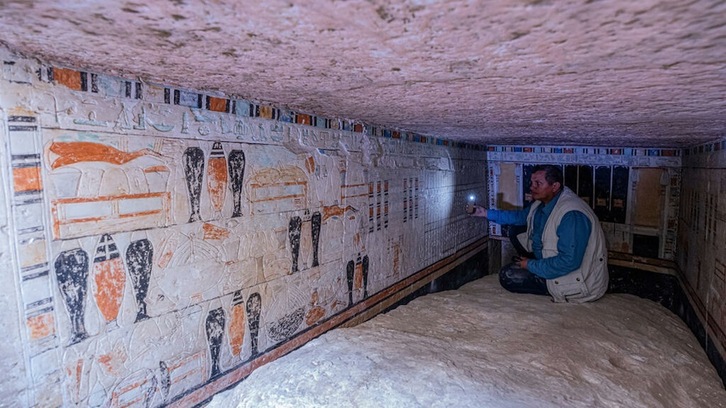 Un arqueólogo muestra a los periodistas detalles de una de las cinco tumbas halladas en Saqqara, al sur de El Cairo.