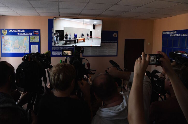 Periodistas rusos siguen a través de una pantalla la sentencia del juicio contra Navalny.