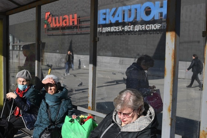 Mujeres esperan al autobús en el exterior de un centro comercial en Moscú. 