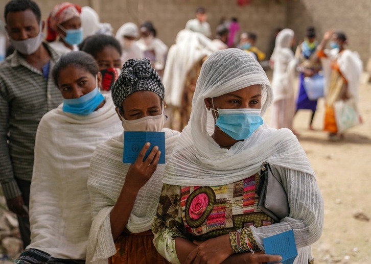 Habitantes de Geha (Etiopía) hacen fila para recibir paquetes de ayuda humanitaria en un punto de entrega gestionado por los Servicios de Auxilio Católico y la Sociedad de Ayuda Humanitaria de Tigré, en junio de 2021.