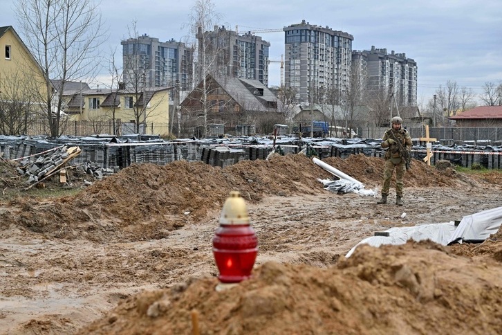 Un militar ucraniano hace guardia cerca de una fosa común en Bucha, el 9 de abril de 2022.