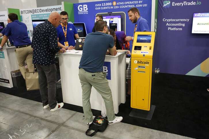 Participantes en la conferencia Bitcoin 2022 de Miami ante un cajero automático.