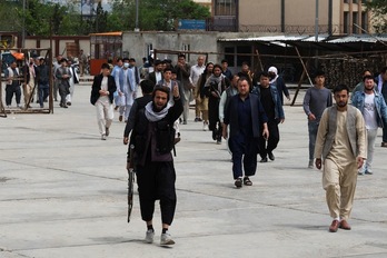 Un combatiente talibán hace un gesto cuando los familiares de las víctimas llegan a un hospital de Kabul después la explosión de bombas en una escuela del barrio de Hazara.