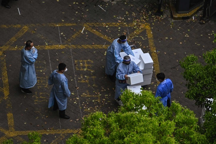 Trabajadores sanitarios trasladan cajas con equipos de protección en el distrito de Jing'an, en Shanghai.