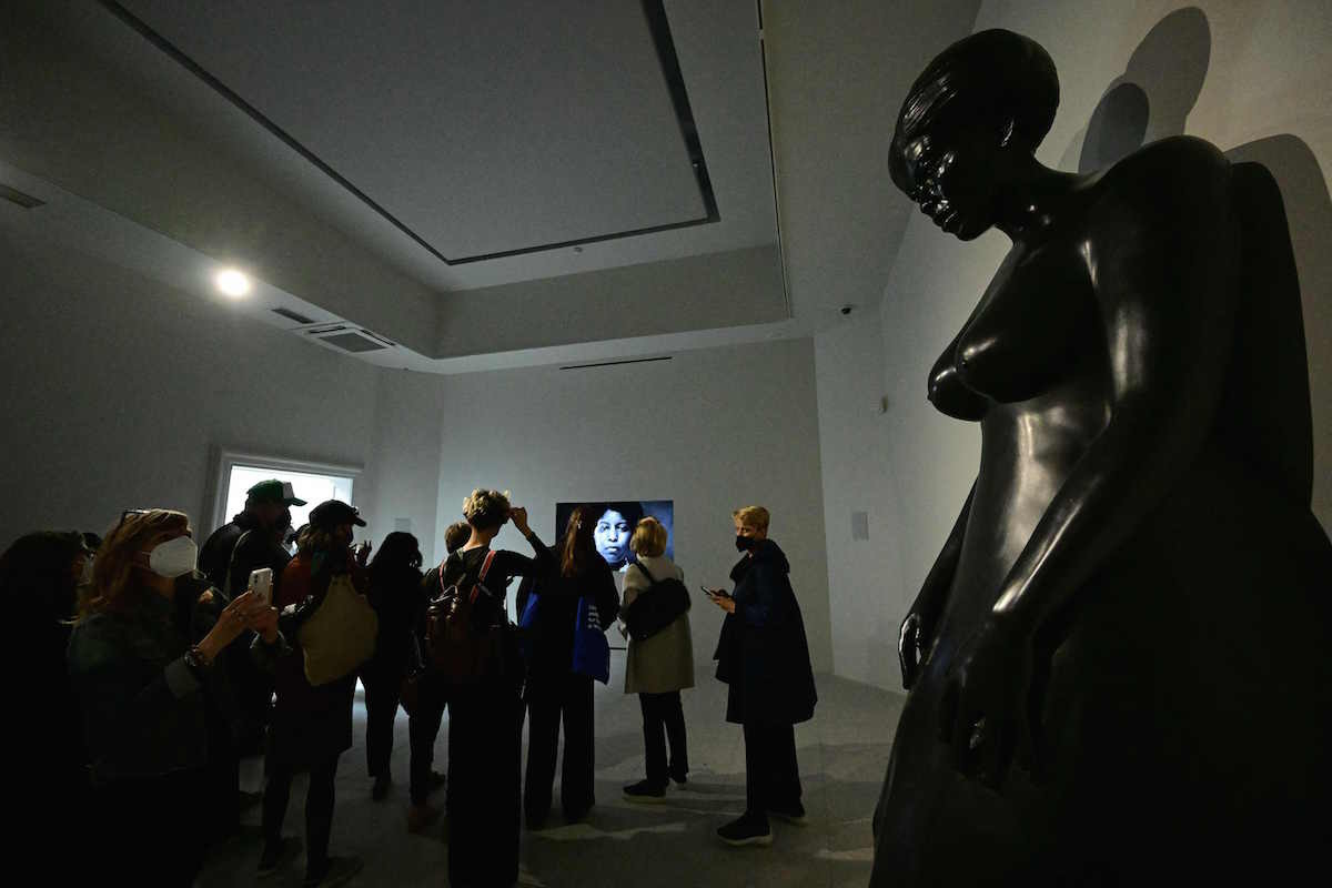 Unos visitantes observan la escultura de bronce por la que ha sido premiada Simone Leigh. (Vicenzo PINTO/AFP)