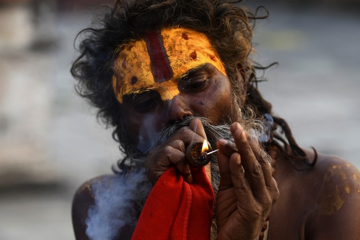 Un sadhu fuma marihuana con una pipa de arcilla tradicional en el templo Pashupatinath, en Katmandú.