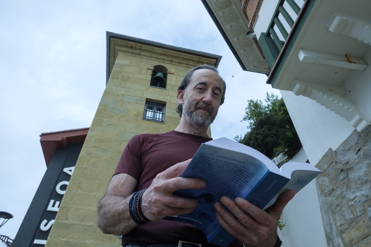 Enrique Santamaría posa con su novela ‘Elkano’ en el puerto de Donostia, ante el Museo Marítimo.