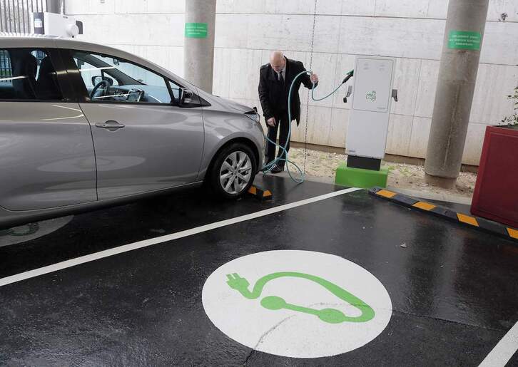 Un hombre enchufa su automóvil en París, en la estación de carga para el personal de servicios públicos de los ministerios de Economía y Finanzas.