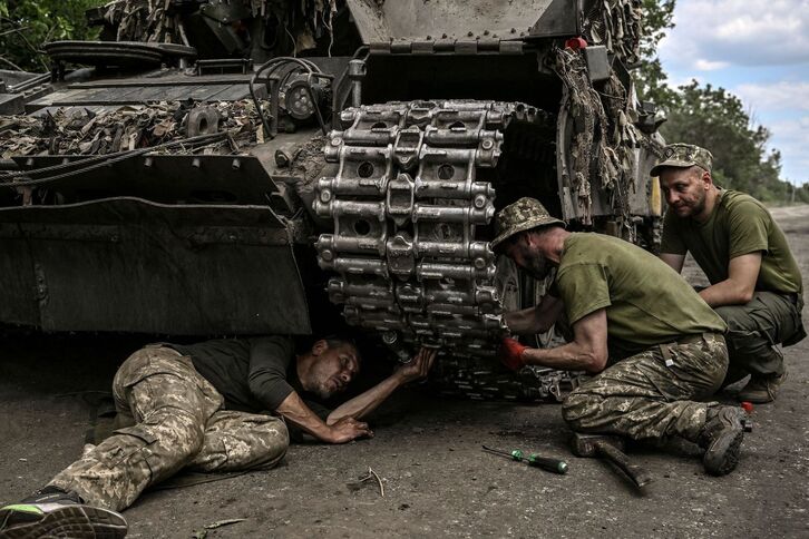 Soldadu ukrainarrak, tanke bat konpontzen saiatzen. 