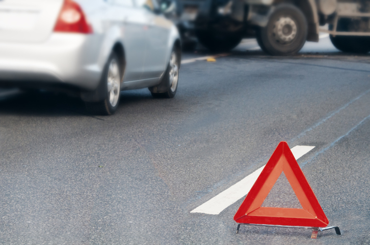 Triángulo de advertencia junto a un accidente de tráfico. 