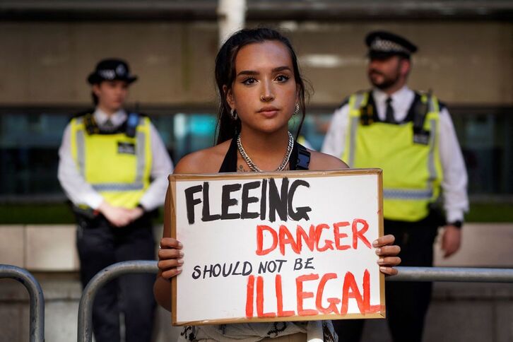 Una manifestante sostiene una pancarta frente al Ministerio del Interior, en Londres el lunes 13 de junio, para protestar contra las deportaciones.