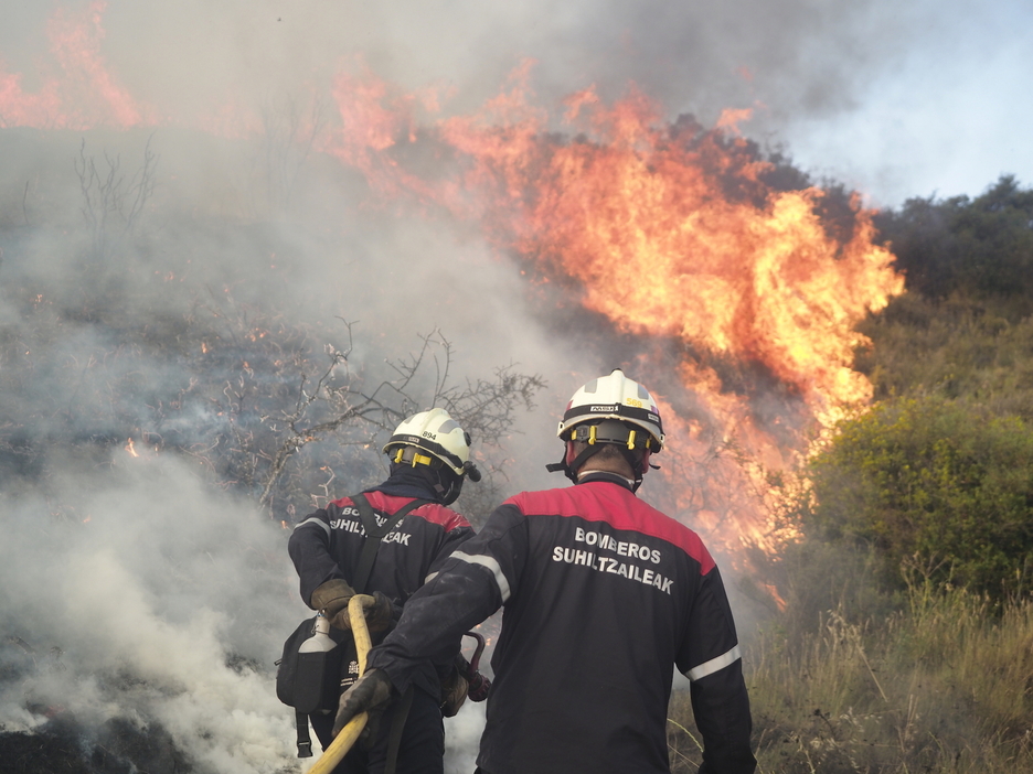 Dos bomberos se acercan a las llamas en Tafalla.