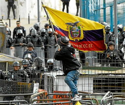 Un manifestante ondea una bandera ante la Policía.