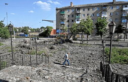 Un hombre camina cerca del cráter creado por el impacto de un misil en Bakhmut, donde espera otra gran batalla del Donbass.