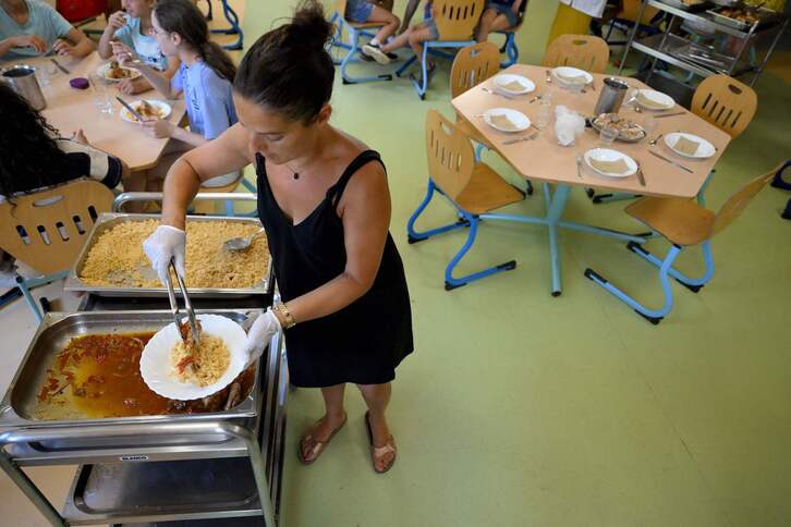 Una trabajadora sirve comidas a escolares en una escuela primaria de Saint-Remy-de-Provence.