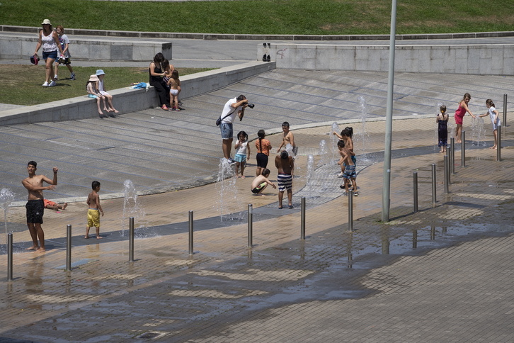 Niñas y niños jugando con el agua en la explanada del Guggenheim, en Bilbo.