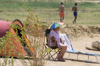Una mujer se protege del calor en el pantano de Alloz, en Lizarra. 
