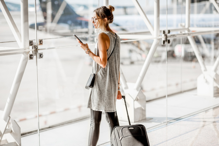 Una mujer mira el móvil en un aeropuerto. 