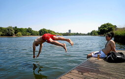 Un hombre salta al lago Serpentine, en Hyde Park (Londres), para refrescarse.