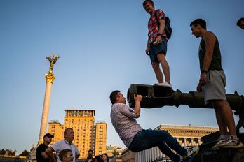 Varios hombres subidos a un tanque ruso destruido en Kiev. 