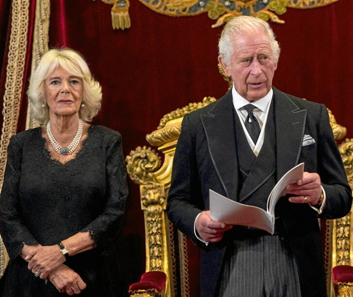 La reina consorte, Camila, escucha a Carlos III.